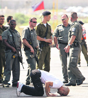 A Palestinian prisoner touches the ground upon his release at the Beitunya checkpoint, outside the West Bank city of Ramallah. Israel freed 198 Palestinian prisoners on Monday. 