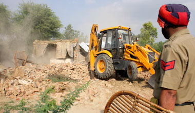 Demolition drive in progress at Dhobiana Basti area in Bathinda on Tuesday.