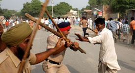 Police cane-charging protesters at Dhobiana Basti area in Bathinda on Tuesday.