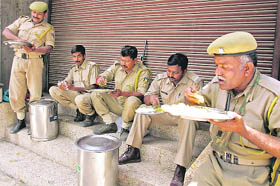 Policemen eat their lunch on a street on the third day of curfew in Srinagar on Tuesday. There were stray incidents of protests.