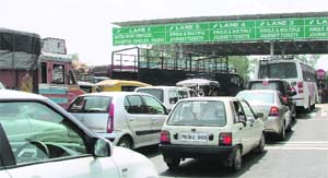 Commuters being allowed to cross the toll barrier without paying tax in Ludhiana on Tuesday