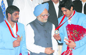 Prime Minister Manmohan Singh with Olympic bronze medal winners boxer Vijender Kumar (R) and wrestler Sushil Kumar at his residence in New Delhi on Tuesday.