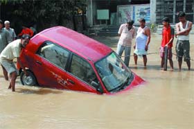 A car sinks as the ground beneath it gives way following a water pipe burst at Kilokari village opposite New Friends Colony in New Delhi