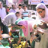 women make purchases in a vegetable market