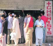 people await their turn outside a medical store