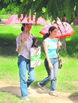 Girls take the shade of umbrellas on a sunny Wednesday afternoon on the PAU campus in Ludhiana.