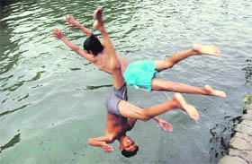Two boys dive into a pool on the Panjab University campus, Chandigarh.