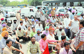 Members of the UT Power Men Union block traffic in Sector 26, Chandigarh, in protest against not giving a regular job to the wife of line man Sandeepan on Thursday. 