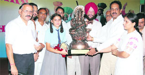 A student receives a memento from SDM Sukhwinder Singh after a debate on female foeticide in Khanna on Thursday.
