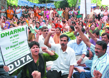 University teachers sit on a dharna in front of the office of the University Grant Commission against the 'unwarranted' delay in the submission of the UGC pay review committee report in New Delhi on Friday.