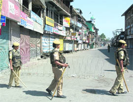 The street presents a deserted look with women CRPF personnel deployed at the Budshah Chowk during curfew in Srinagar on Friday.