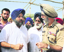 SAD chief Sukhbir Singh Badal talks to DGP N.P.S. Aulakh at Banawali village in Mansa on Friday. 