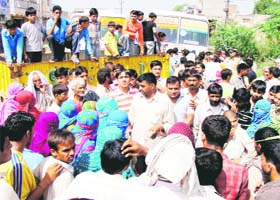Residents block the Rohtak-Sonepat road in protest against the shortage of water for irrigation at Kansala