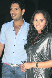 Cricketer Yuvraj Singh (L) with tennis player Sania Mirza at the launch of an international menswear manufacturing company in Mumbai on Saturday.