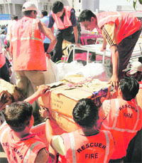Members of a rescue team from the Gujarat State Disaster Management Authority load relief material at Ahmedabad airport before leaving for the flood-affected areas of Bihar on Sunday