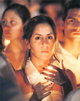 A demonstrator holds a lit candle at the Macroplaza in downtown Monterrey on Saturday. More than 1,50,000 Mexicans dressed in white marched in protest against a wave of kidnappings and gruesome murders, putting pressure on President Felipe Calderon to meet his promises to crack down on crime. 