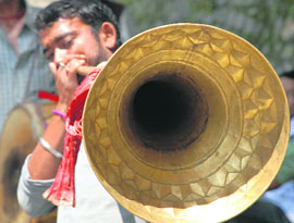 A man plays an Himachali instrument, called thonkru. It is normally played at the time of festivals in the state.