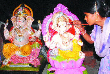 An artisan gives final touches to Ganpati idols in Jalandhar on Tuesday.