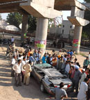 A crowd surrounds the damaged car, whose driver was killed, as it fell down from the incomplete overbridge on the Bathinda-Talwandi Sabo road on Thursday.