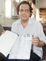 Sunil Sood, an NRI whose land was sold by a local Congress leader, shows the orignal documents of the land.