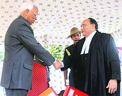 Governor N.N. Vohra shakes hands with Mr Justice Manmohan Sarin before he takes oath as the new Chief Justice in Srinagar on Thursday.