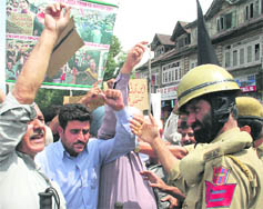 Policemen arrest SRTC employees during a protest in Srinagar on Thursday.
