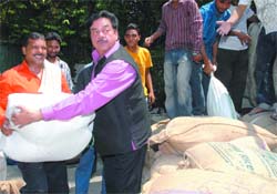 Actor turned politician Shatrughan Sinha gives relief material for Bihar flood victims at his residence in New Delhi on Sunday.