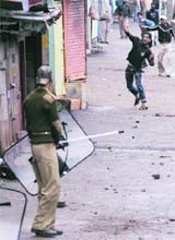 Protesters throw stones at the security forces during a demonstration against the killing of a youth in Srinagar on Sunday. 
