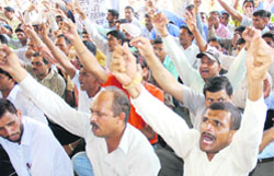 Guest teachers stage a protest in Karnal on Monday against the Rohtak firing incident in which one teacher was killed and several others were injured