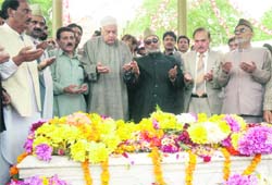 National Conference patron Farooq Abdullah pays floral tributes to his father, Sheikh Abdullah, on his 26th death anniversary in Srinagar on Monday. 