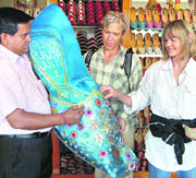 Foreign tourists look at a big Punjabi jutti at a shop in Amritsar on Monday.