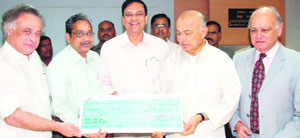 S. Majumdar, director (projects), and J. Shreedharan, director (finance), PowerGrid, present a cheque of Rs 7 crore for Prime Minister's Relief Fund to Sushil Kumar Shinde, union minister for power, and Jairam Ramesh, union minister of state for power, in New Delhi on Tuesday.