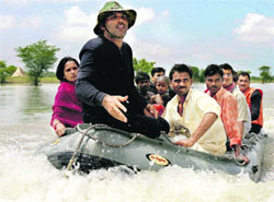 Flood-affected villagers ride on an inflatable boat as they are evacuated by Navy personnel in Sapual of Bihar on Tuesday.
