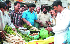 Members of Khel Udyog Sangh sell vegetables to protest against the state government for not scrapping VAT on sports goods in Jalandhar on Wednesday. 