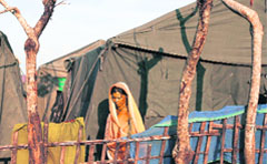 A flood-affected woman goes about her daily life at a temporary flood relief camp in Sapual district in Bihar