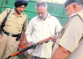 Police officials inspect the rifle after the incident in Chandigarh