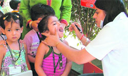 A doctor examines kids during a dental check-up camp at Pumpkins Kindergarten, in Ludhiana