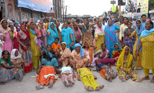 Residents of Dhobiana Basti, who had been uprooted during a demolition drive by PUDA, staging demonstration at the gate of the bus stand in Bathinda on Friday. 