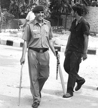 A cop carries a slugger and lathis, which were found near SD College, Sector 32, Chandigarh, on Friday.