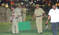(Left) Policemen inspect the blast site at Central Park, Connaught Place in New Delhi on Saturday. Several blasts rocked the national Capital on Saturday evening. (Right) A man carries an injured person to hospital.