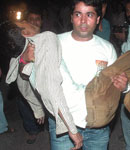 (Left) Policemen inspect the blast site at Central Park, Connaught Place in New Delhi on Saturday. Several blasts rocked the national Capital on Saturday evening. (Right) A man carries an injured person to hospital.