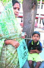Six-and a half-year old Chandra Prakash with his mother Laxmi wait to receive his father's body at RML Hospital's mortuary in New Delhi on Sunday