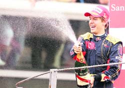 Toro Rossos German driver Sebastien Vettel celebrates on the podium of the Monza racetrack near Milan, after the Italian Formula One Grand Prix on Sunday.