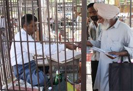A vendor selling stamps from his stall in Bathinda. The caged structure of vendors is a common sight in the city.