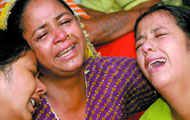 Relatives of a blast victim mourn in New Delhi on Monday. (Right) Children of Gaffar Market bomb blast victims play in the rain.