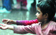 Relatives of a blast victim mourn in New Delhi on Monday. (Right) Children of Gaffar Market bomb blast victims play in the rain.