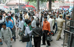 Office workers gather outside the New Delhi House building at Barakhamba Road in Central Delhi after a hoax bomb call was received on Monday morning. 