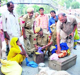 Policemen check the luggage of passengers at Karnal railway station on Monday following an alert after the Delhi bomb blasts