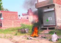 Thick smoke emanates from the burning of oil filters and other waste material by scrap dealers in Kaithal.
