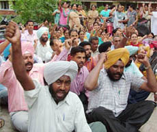 Agitated teachers shout slogans against the SSA authorities in Jalandhar on Monday.